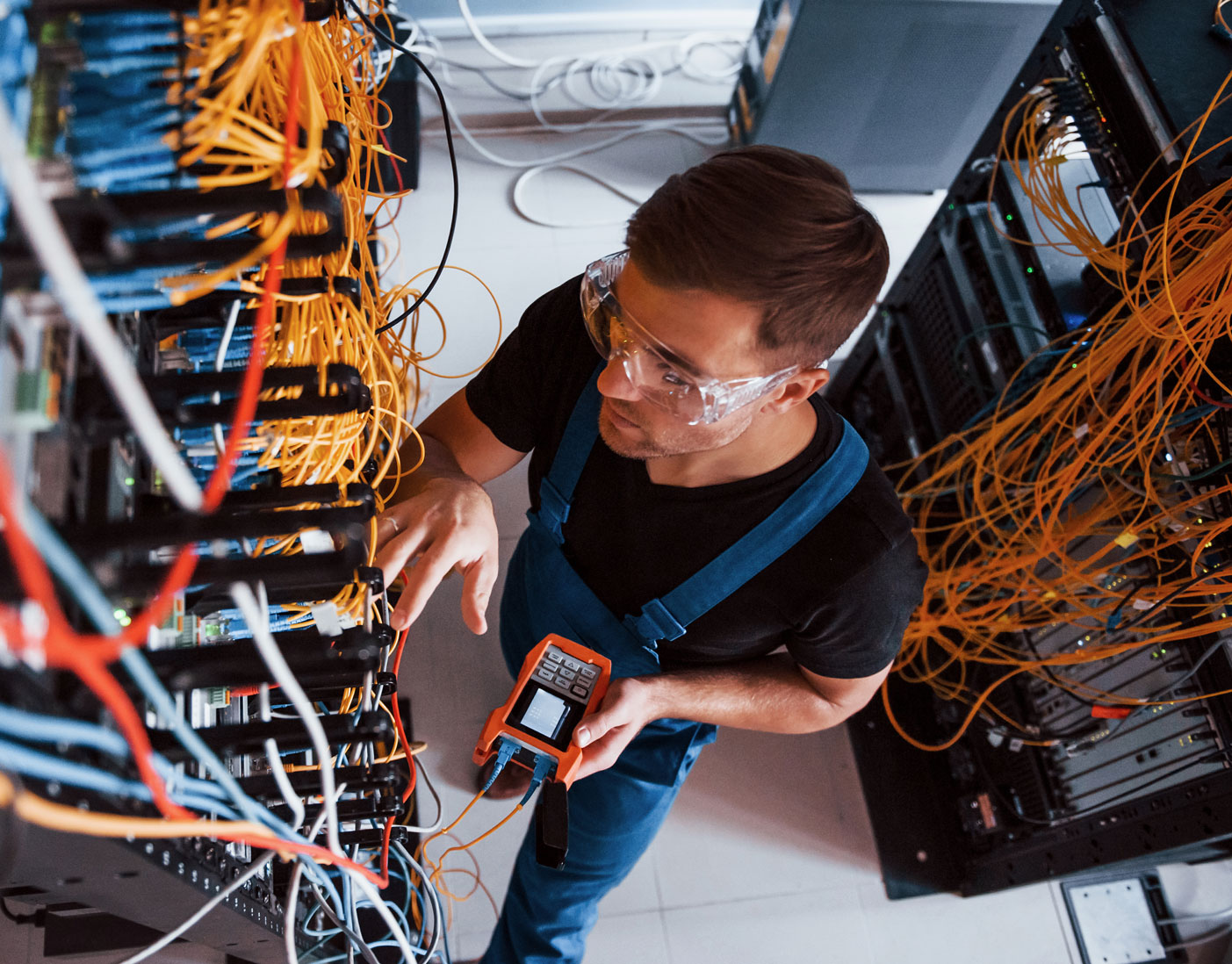 top-view-young-man-uniform-with-measuring-device-that-works-with-internet-equipment-wires-server-room